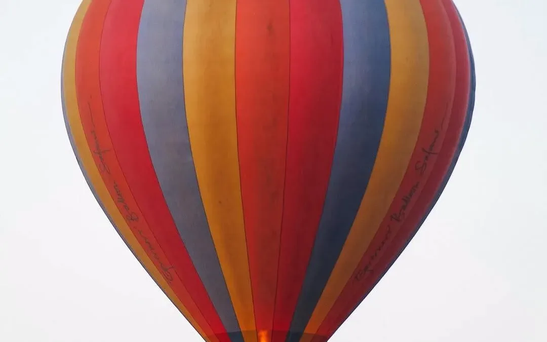 Hot air balloon rising over the Maasai Mara at dawn